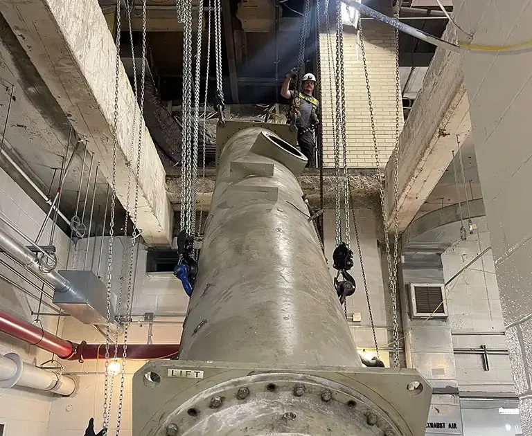 CMR Crane and Rigging crew using chain hoists for specialized indoor machinery rigging in Ashburn, Virginia.