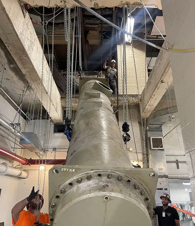 CMR Crane and Rigging crew using chain hoists for specialized indoor machinery rigging in Ashburn, Virginia.